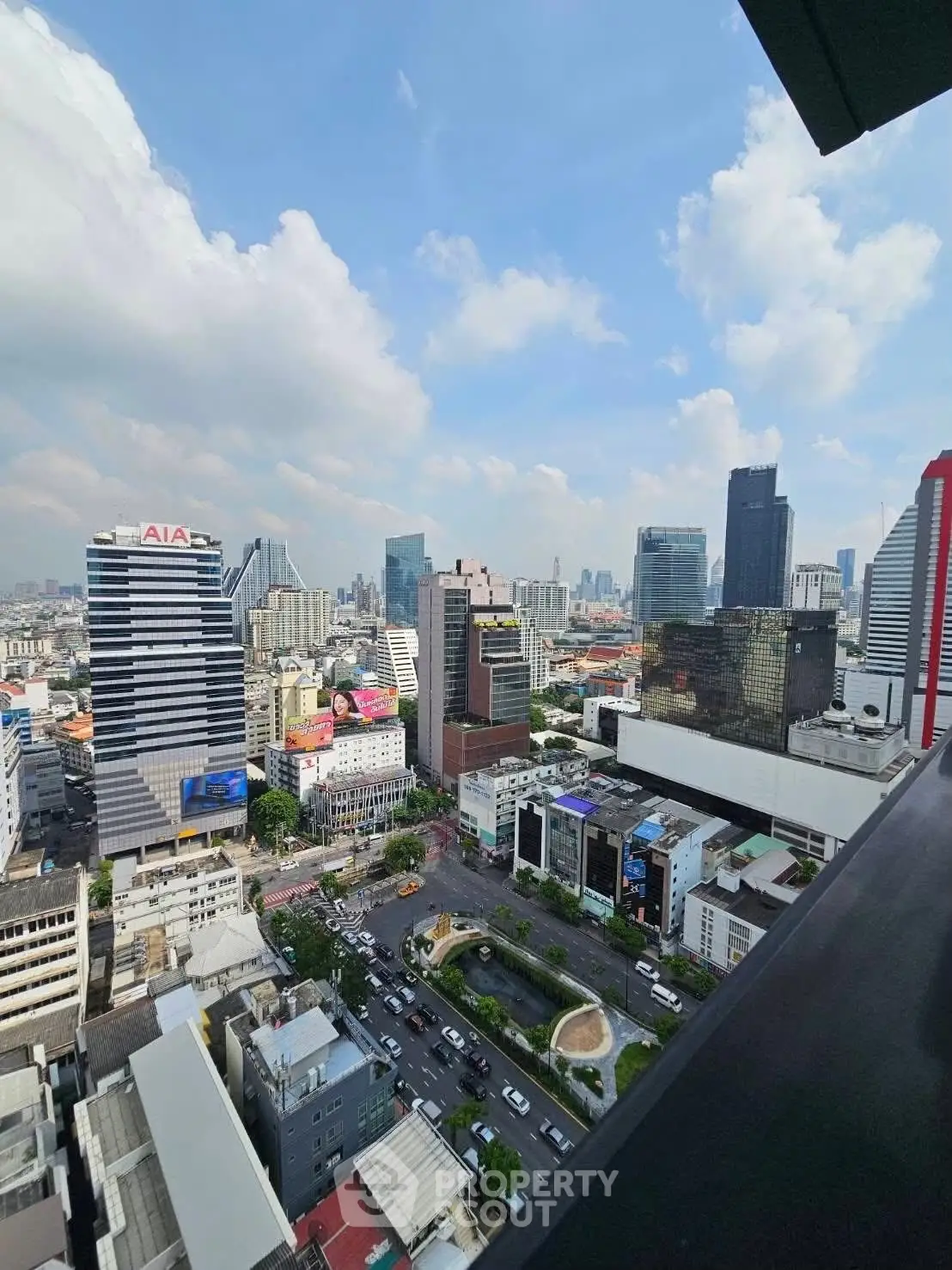 Stunning cityscape view from high-rise balcony with clear blue sky.