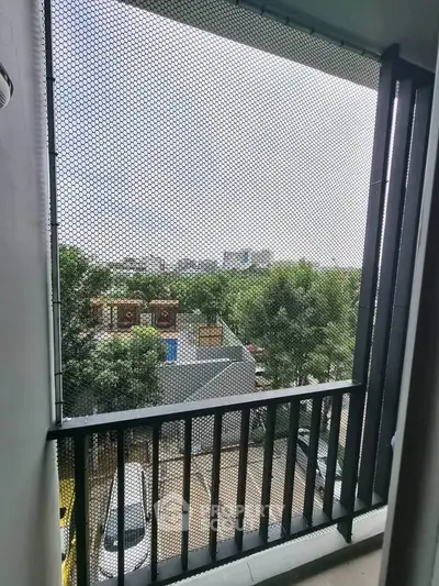 Charming balcony view with lush greenery and urban skyline, perfect for relaxation and enjoying city life.