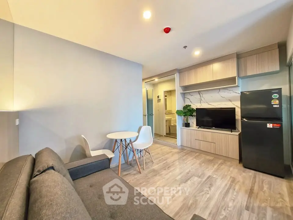 Modern living room with sleek furniture and open layout, featuring a cozy sofa and stylish dining area.