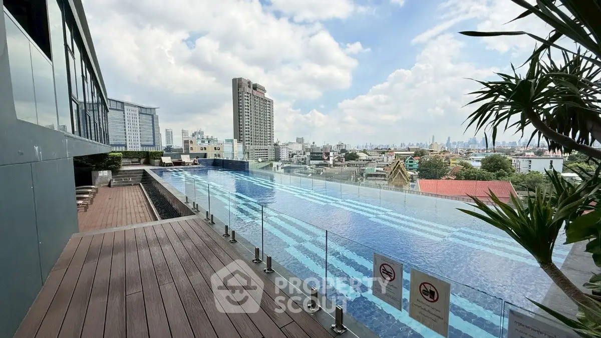 Stunning rooftop pool with panoramic city views and modern glass railing.