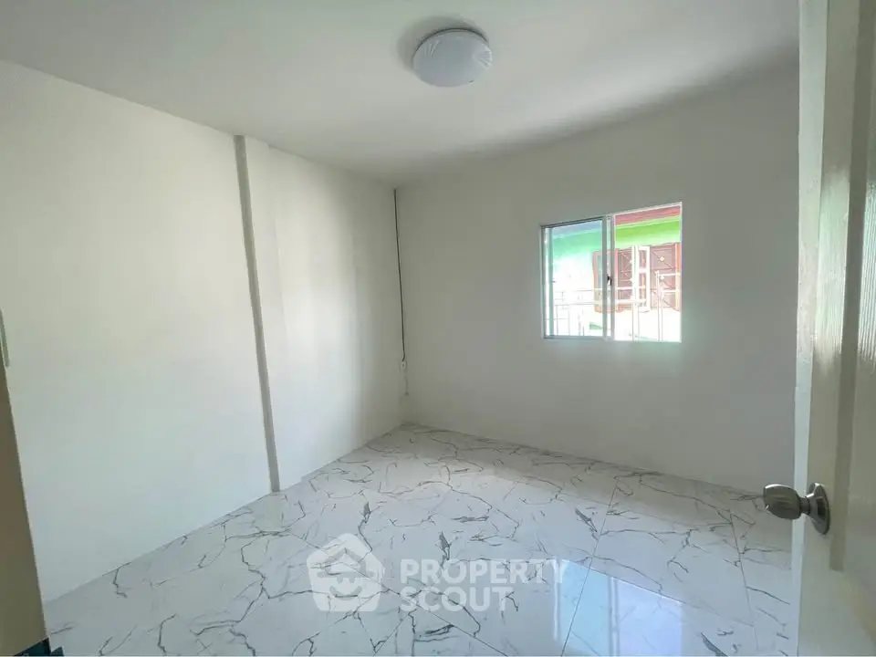 Spacious empty room with marble flooring and natural light
