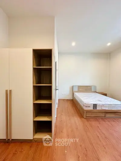 Spacious bedroom with wooden flooring and modern furniture