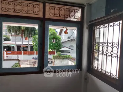 Charming balcony view with lush greenery and neighborhood houses.