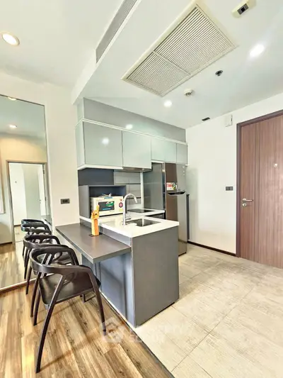 Modern kitchen with sleek cabinetry and breakfast bar in a stylish apartment.
