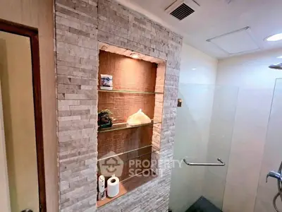 Elegant bathroom with stone accent wall and glass shower enclosure