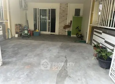 Spacious garage area with sliding glass doors and potted plants