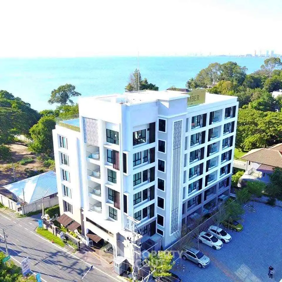 Stunning modern apartment building with ocean view, ample parking, and lush greenery, perfect for luxury living.