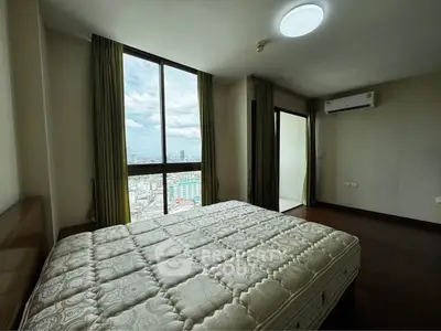 Spacious bedroom with large window offering stunning city views, featuring a comfortable mattress and air conditioning.