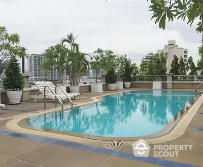 Luxurious rooftop pool with city views and lush greenery, perfect for relaxation and leisure.