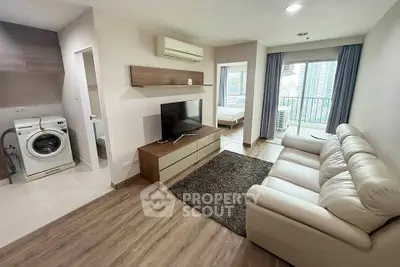 Modern living room with washing machine, TV, and balcony view in a stylish apartment.