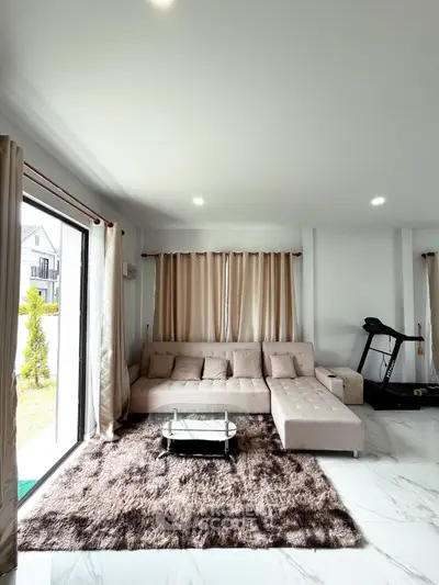 Spacious modern living room with plush sofa and treadmill, perfect for relaxation and fitness.