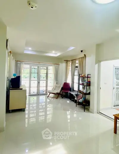 Spacious living room with modern decor and large windows for natural light.