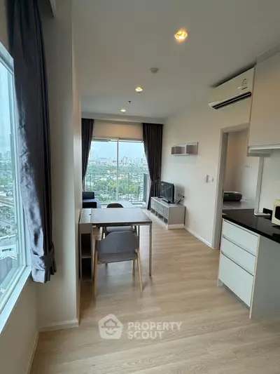 Modern living room with city view, featuring sleek furniture and large windows for natural light.