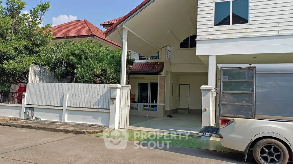 Charming suburban house with spacious driveway and lush greenery, perfect for family living.