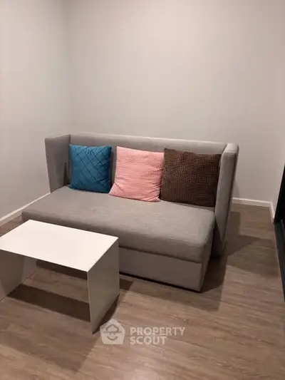 Cozy living room with modern sofa and stylish cushions in a minimalist setting.
