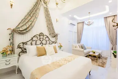 Luxurious bedroom with elegant decor and high ceilings, featuring a stylish bed and cozy seating area.