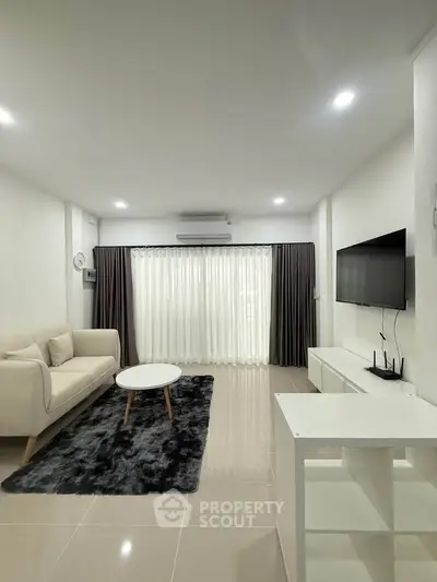 Modern living room with sleek furniture and large window for natural light.