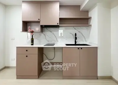 Modern kitchen with sleek cabinetry and marble backsplash in a stylish apartment.