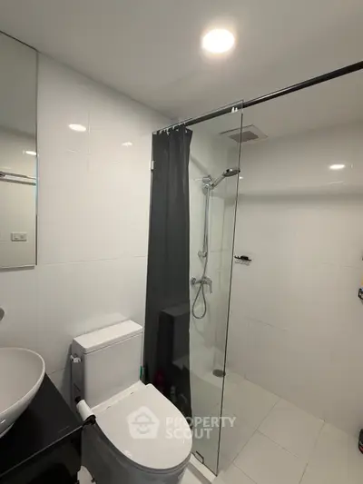 Modern bathroom with glass shower and sleek fixtures in a contemporary apartment.
