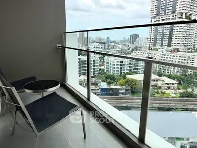 Modern balcony with city view and sleek glass railing in urban high-rise.