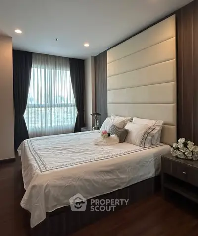 Luxurious bedroom with elegant decor and large window offering natural light.