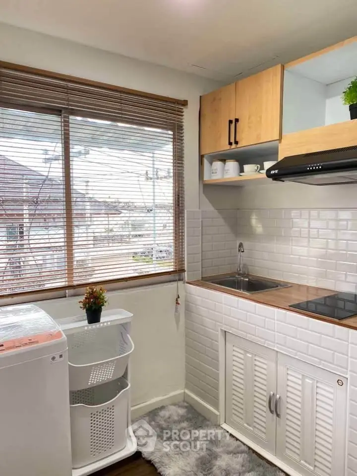 Charming kitchen with modern appliances and cozy decor, perfect for urban living.