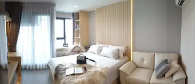 Luxurious modern bedroom with cozy seating and elegant decor, perfect for relaxation and comfort.