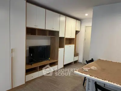 Modern living room with built-in storage and TV unit, featuring sleek design and ample space.