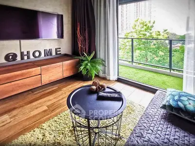 Stylish living room with balcony view, modern decor, and natural light.