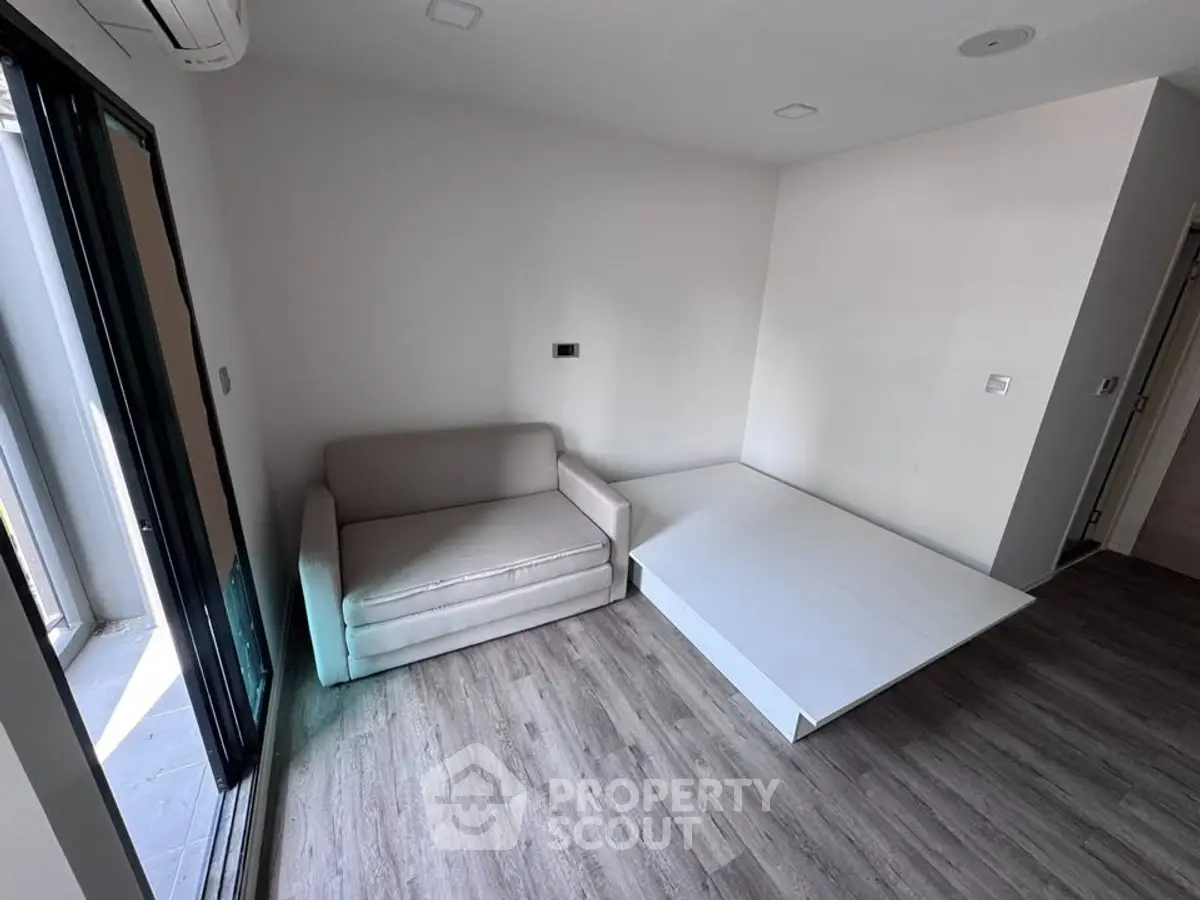 Modern minimalist living room with sleek flooring and compact sofa bed.