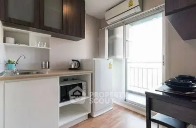 Modern kitchen with open layout and balcony access, featuring sleek appliances and stylish cabinetry.