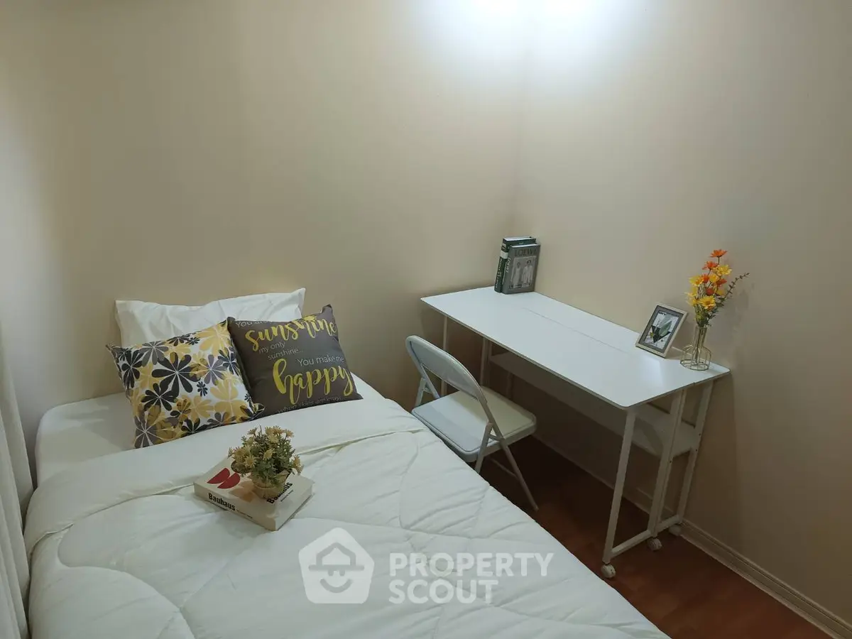 Cozy bedroom with single bed, desk, and decorative accents for a welcoming atmosphere.