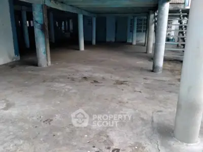 Spacious open concrete area with supporting pillars, ideal for parking or storage.