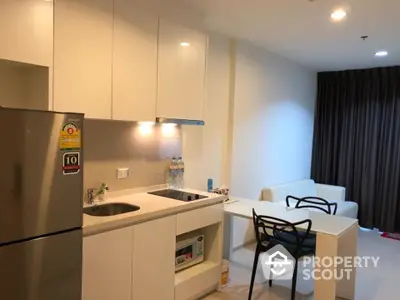 Modern kitchen and dining area with sleek white cabinets and cozy seating.