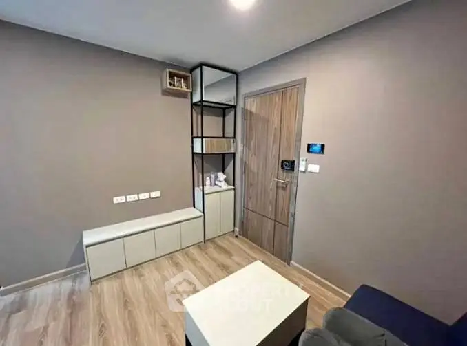 Modern minimalist living room with wooden flooring and sleek storage solutions.