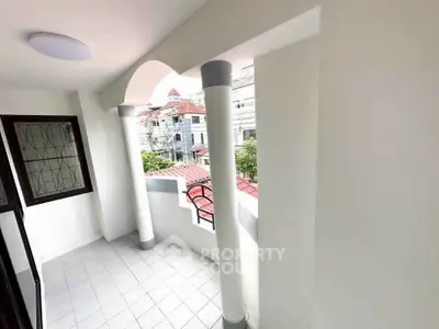 Charming balcony with elegant columns and city view, perfect for relaxation and enjoying the outdoors.