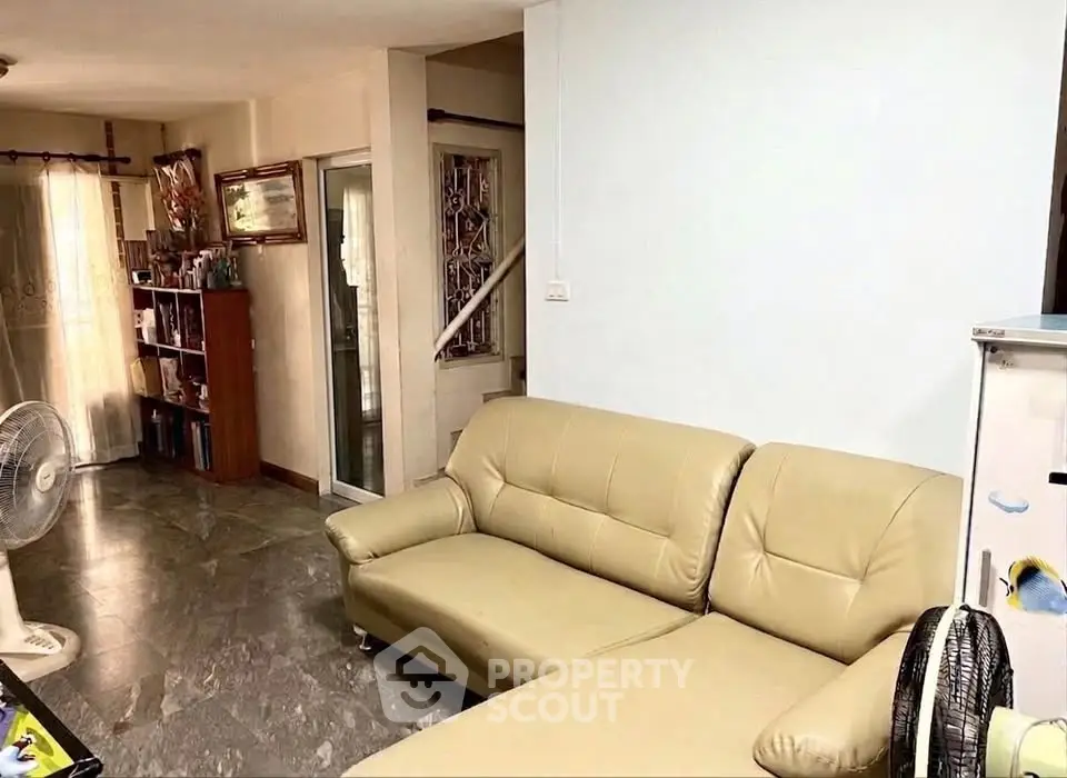 Spacious living room with modern beige sofa and stylish decor, perfect for relaxation and entertaining.