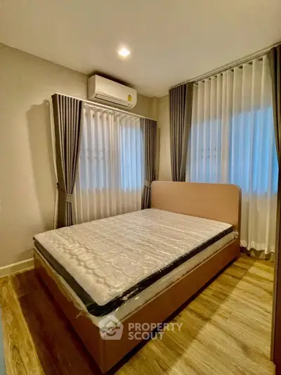 Cozy bedroom with modern design, featuring a comfortable bed and elegant curtains.