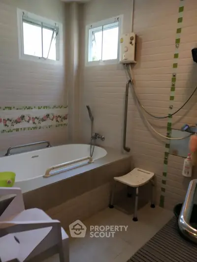 Modern bathroom with bathtub and shower, featuring tiled walls and natural light.