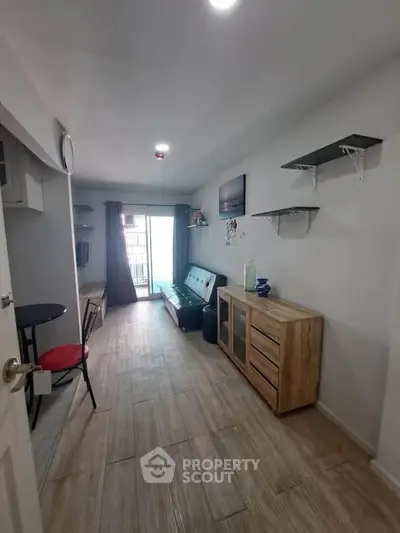 Cozy living room with modern decor and balcony access in a stylish apartment.