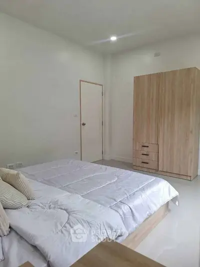 Modern minimalist bedroom with wooden wardrobe and cozy bedding