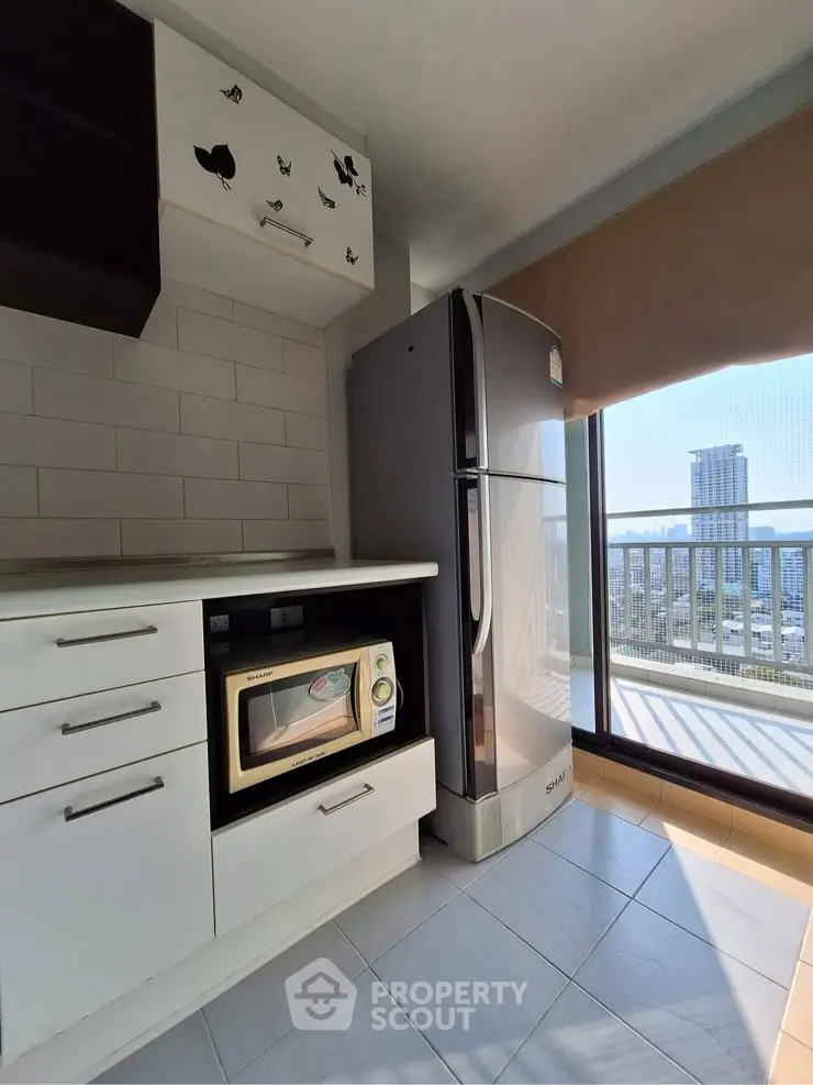 Modern kitchen with sleek appliances and city view from balcony