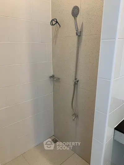 Modern bathroom shower area with sleek tile design and contemporary fixtures.