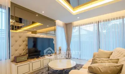 Luxurious living room with modern decor, large TV, and plush seating in a bright, airy space.