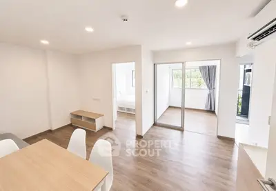 Modern open-plan living room with dining area and balcony access