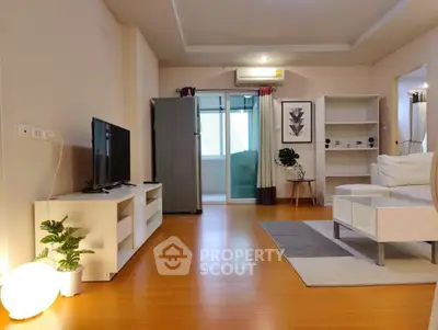 Modern living room with sleek furniture and natural light, featuring a stylish TV unit and cozy decor.