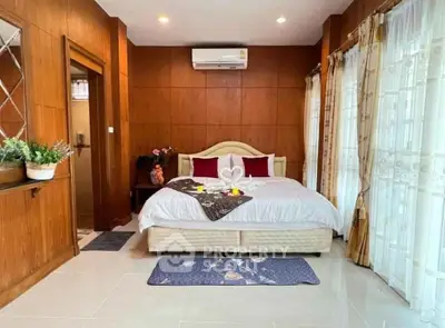 Luxurious bedroom with elegant decor and natural light, featuring a cozy bed and stylish wooden accents.