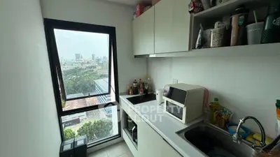 Compact kitchen with city view, featuring modern appliances and sleek cabinetry, ideal for urban living.