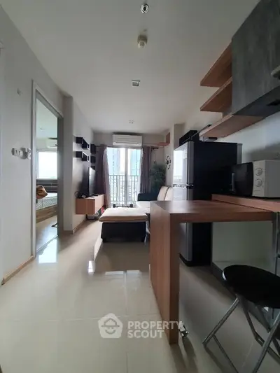 Modern apartment interior with open kitchen and living area, featuring sleek design and natural light.