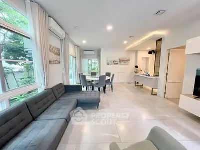 Spacious modern living room with large windows and elegant dining area